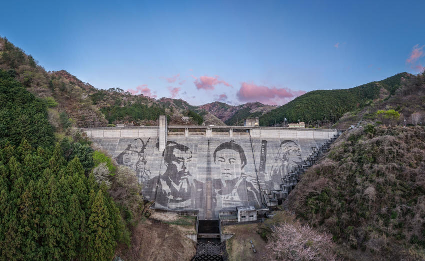 Reverse-Graffiti-Kunstwerk auf der 56 Meter hohen und 228 Meter breiten Staumauer des Matsudagawa-Staudamms in Ashikaga (Japan). Künstler Klaus Dauven gestaltet das monumentale Motiv gemeinsam mit Kärcher ausschließlich durch gezielte Hochdruckreinigung.