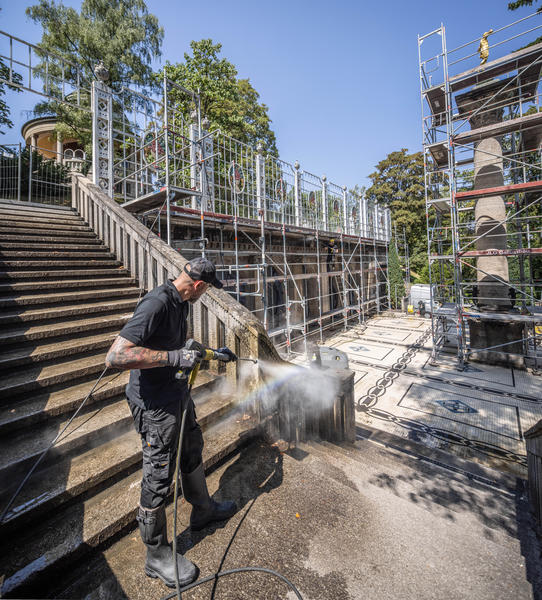 Die Reinigung umfasst neben der Treppenanlage und der Balustrade auch die Terrasse und die mehr als zehn Meter hohe Säule des Marmorsaals. (Bild: Kärcher)

Bild 4: Die Arbeiten an der hohen Säule werden von einem Gerüst aus durchgeführt. Heißer Dampf löst den Bewuchs, ohne die historische Steinoberfläche unnötig mechanisch zu belasten. (Bild: Kärcher)