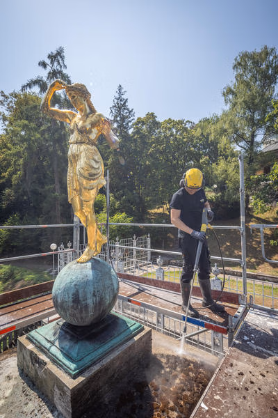 Die Reinigung umfasst neben der Treppenanlage und der Balustrade auch die Terrasse und die mehr als zehn Meter hohe Säule des Marmorsaals. (Bild: Kärcher)
Bild 4: Die Arbeiten an der hohen Säule werden von einem Gerüst aus durchgeführt. Heißer Dampf löst den Bewuchs, ohne die historische Steinoberfläche unnötig mechanisch zu belasten. (Bild: Kärcher)