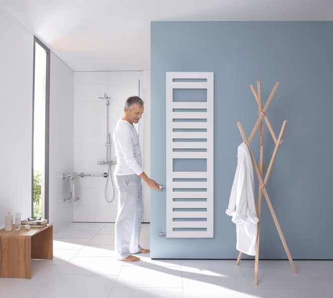 Geteilte Darstellung eines älteren und eines modernisierten Badezimmers mit blauem Badheizkörper.