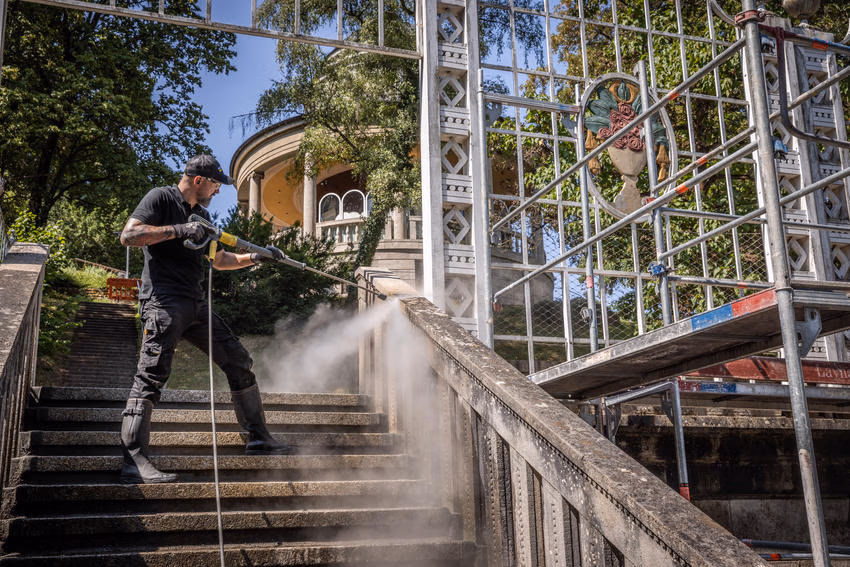 Mit heißem Dampf entfernt ein Kärcher-Reinigungsexperte biogenen Bewuchs von der steinernen Balustrade an der Treppenanlage des Marmorsaals. (Bild: Kärcher)