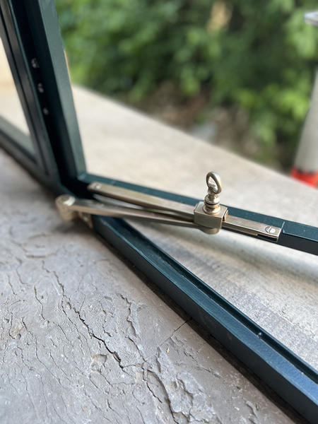 Geöffneter historischer Fensterflügel mit Metallbeschlag