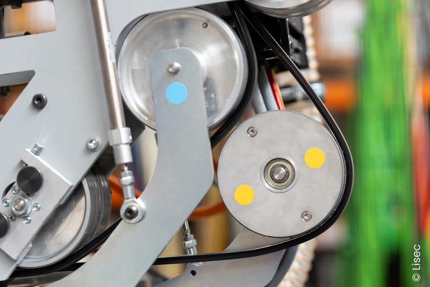 Schwarzer Abstandhalter läuft über Metallrollen im LiSEC-Applikator.