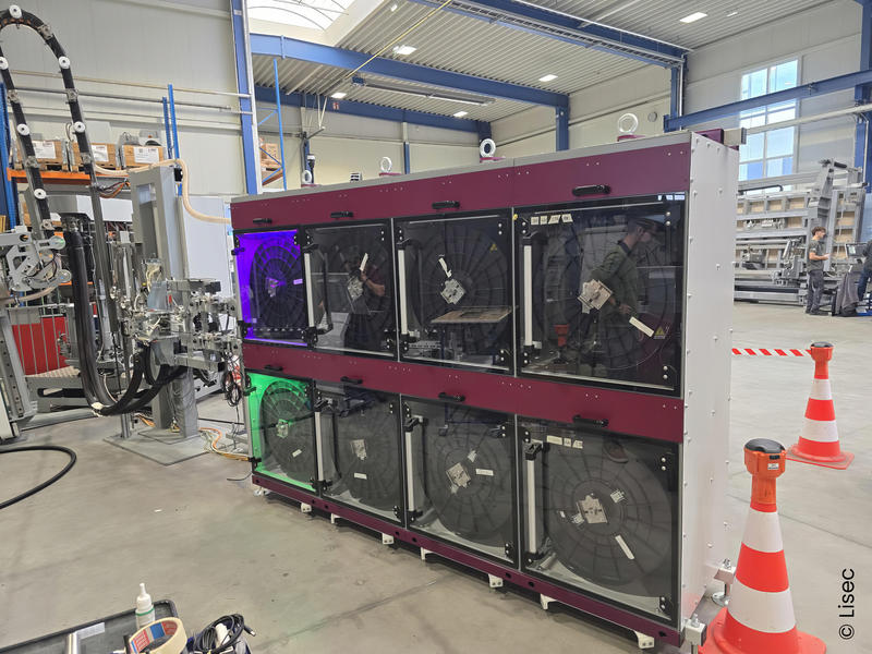Magazin mit mehreren Rollen flexibler Abstandhalter neben der LiSEC-Anlage.