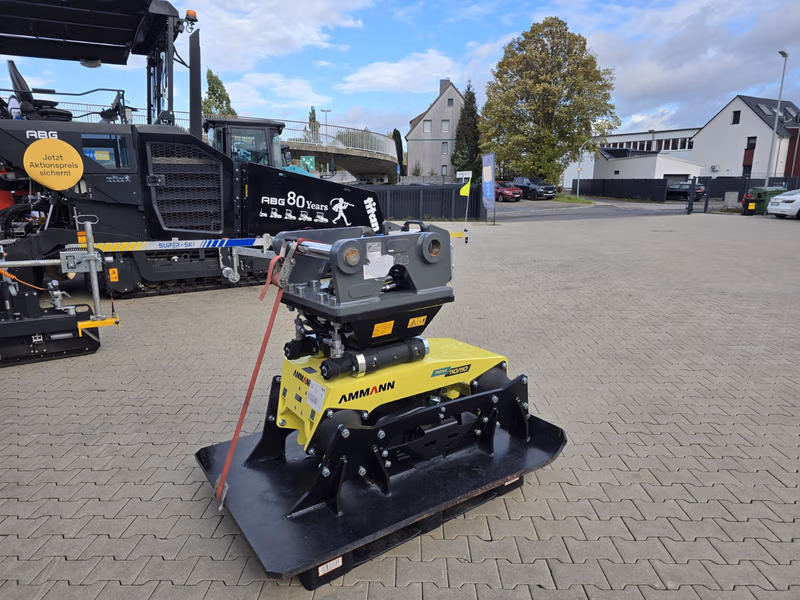 Ammann-Anbauverdichterplatte mit Schnellwechselaufnahme vor einem schwarzen Asphaltfertiger