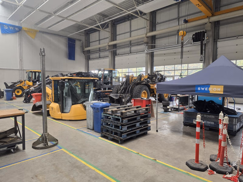 Werkstatthalle bei Swecon in Bochum mit Radladern, Bauteilen und Arbeitsplätzen.