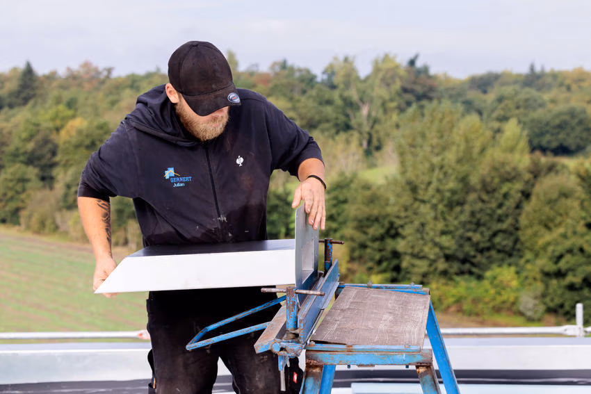 Dachdecker beim Abkanten eines Rechteckspeiers an einer mobilen Abkantbank