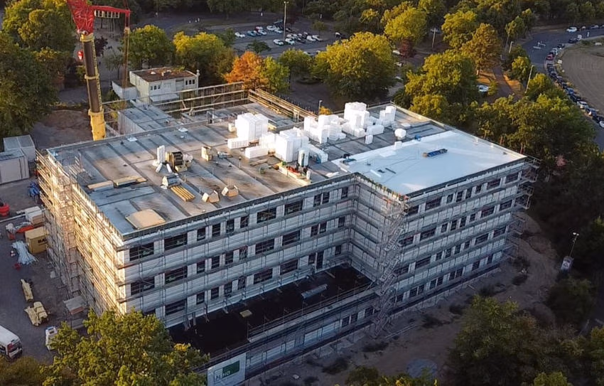Luftaufnahme der Baustelle der Realschule Hackenbroich mit Kran und Dacharbeiten