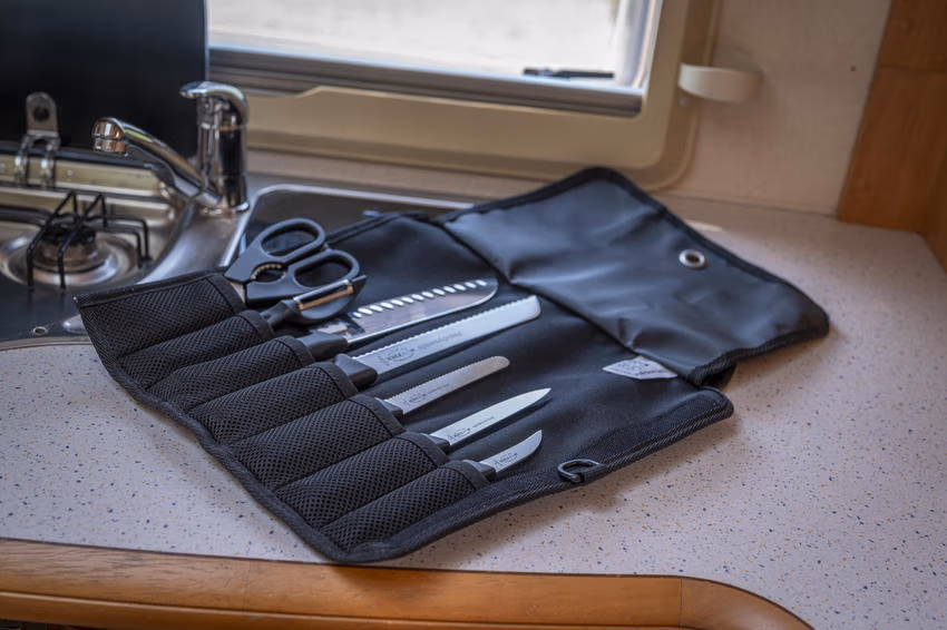 F. DICK-Outdoor-Set mit fünf Messern, Küchenschere und Schäler in einer geöffneten schwarzen Rolltasche.