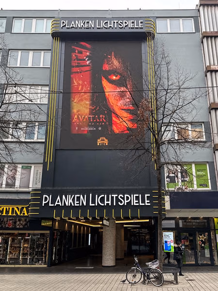 Fassade und Eingang der Planken Lichtspiele Mannheim mit großem Filmplakat.