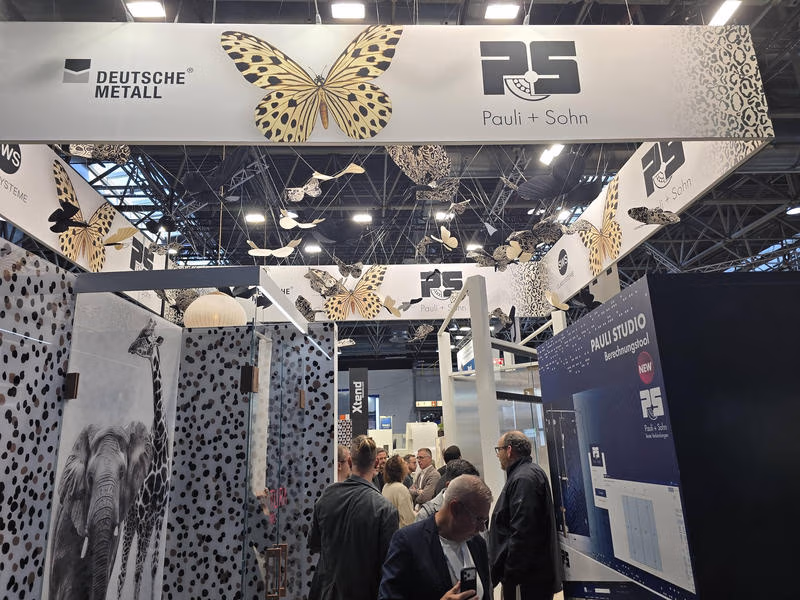 Messestand von Pauli + Sohn und Deutsche Metall mit Ganzglasduschen und großem Schmetterlingsmotiv.