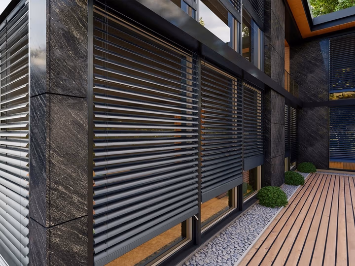 Fassadenraffstoren von Drutex an einem Wohnhaus mit Holzterrasse