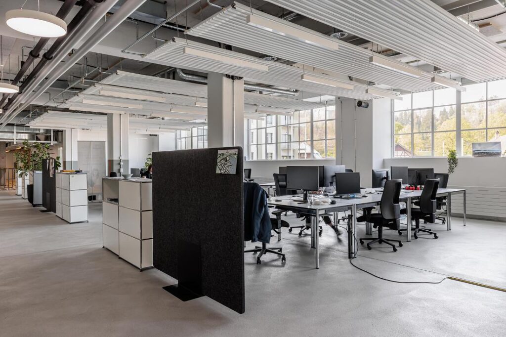 Coworking-Raum im ZID mit abgehängten Zehnder Deckenstrahlplatten im industriellen Stil.